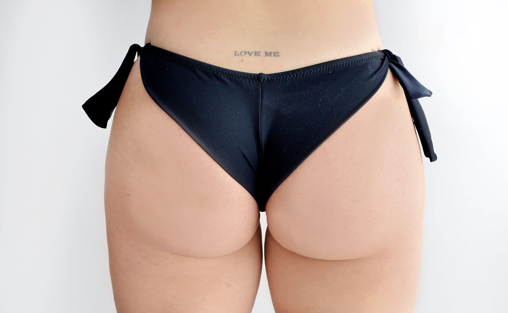 Black brasil bikini bottom with bow sides worn by a sunlover swimwear model