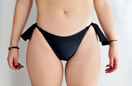 Sunlover Swimwear model wearing a black bikini bottom with bow side-ties