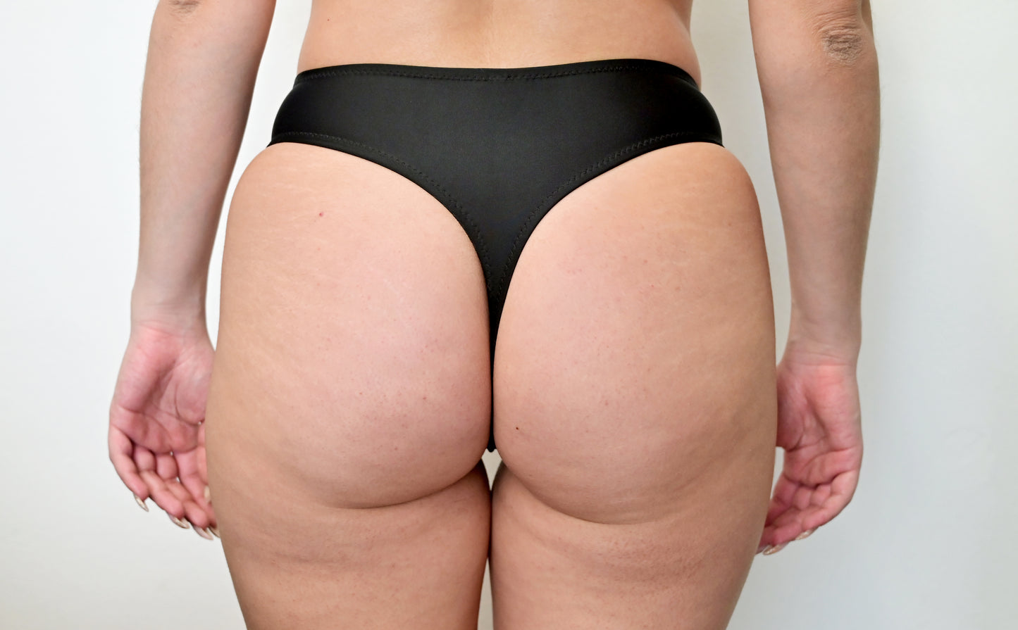 Sunlover Swimwear model wearing a black G-string bikini (back view) (Colour: BLK)