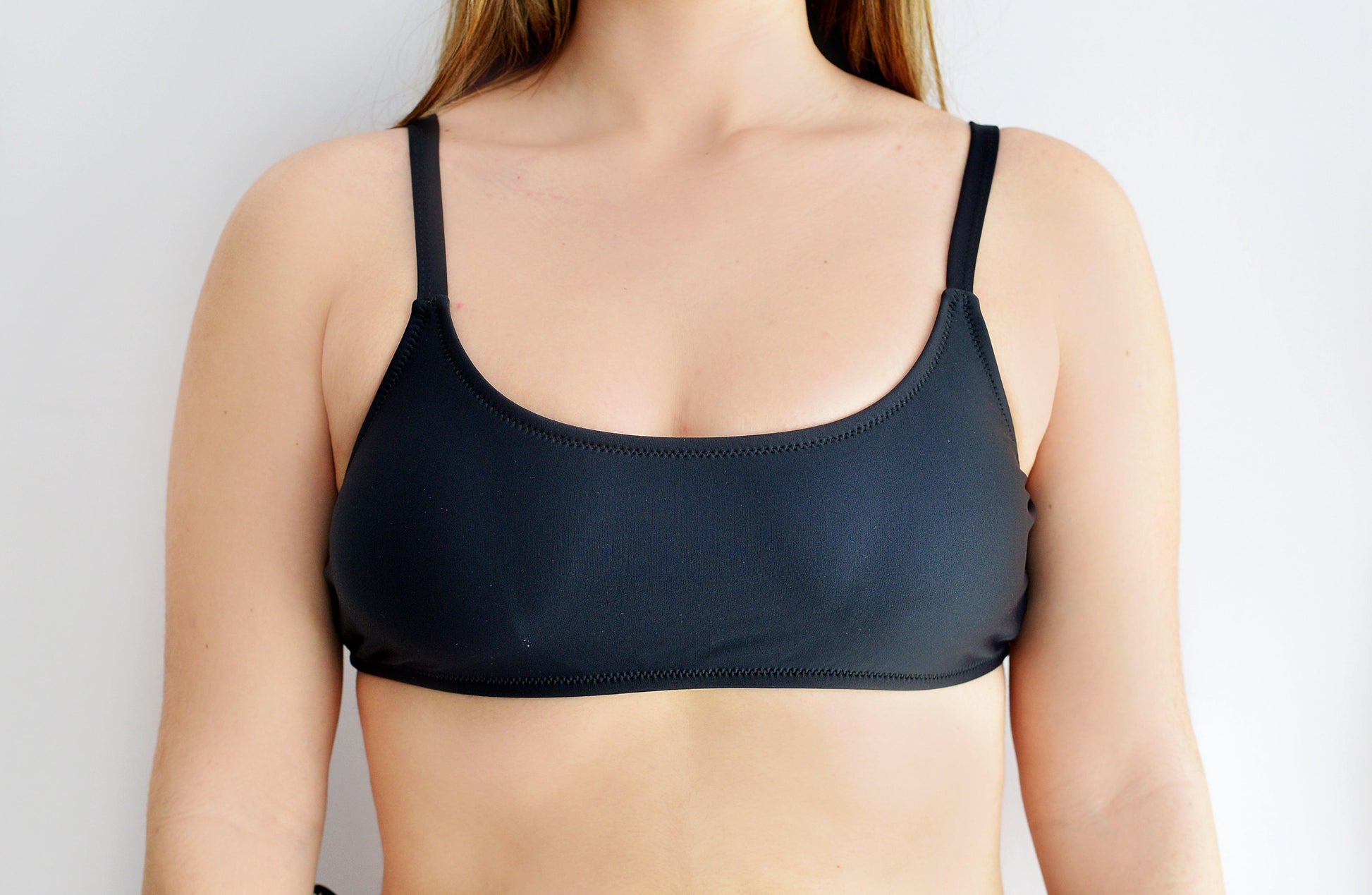 Black sports bra type bikini top worn by a sunlover swimwear model