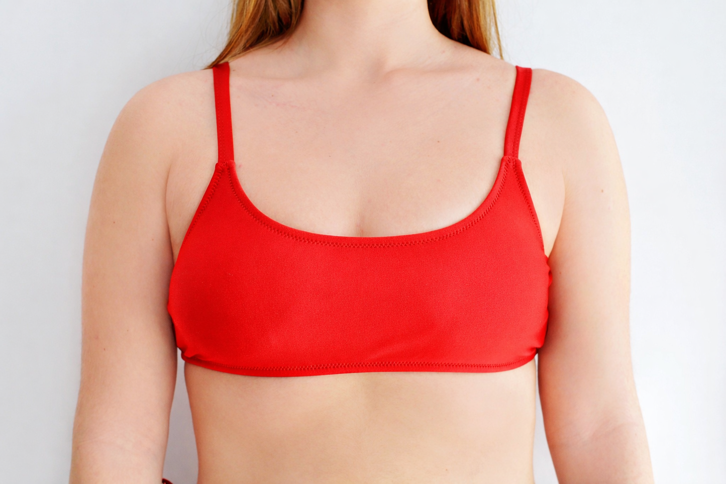 Red sports bra type bikini top worn by a sunlover swimwear model