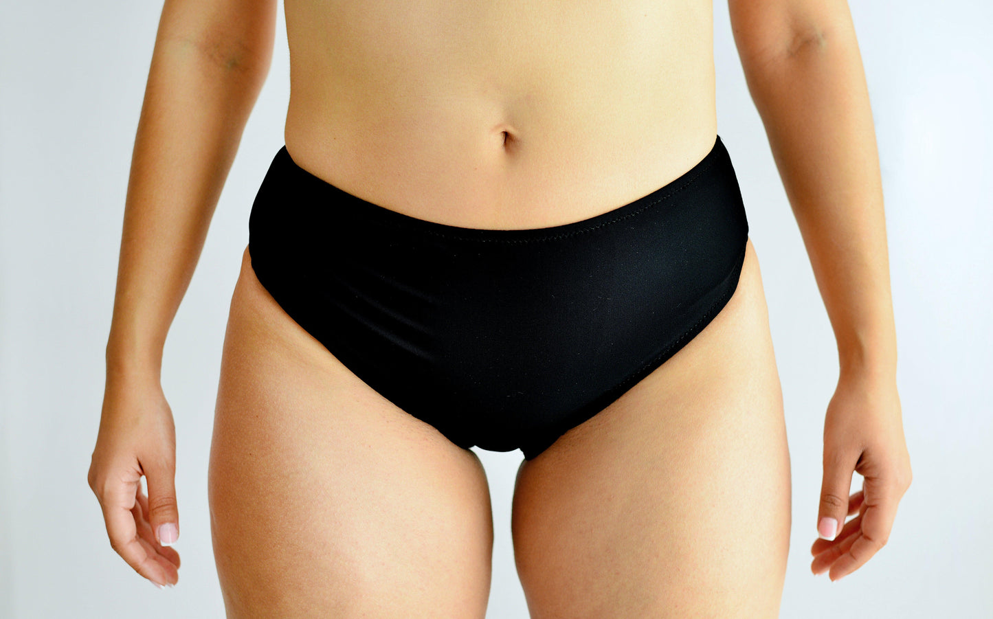 Sunlover Swimwear model wearing black high-waisted swimwear on a plain background