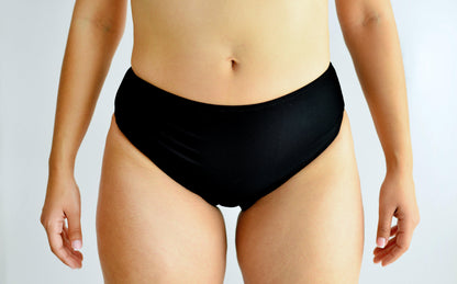 Sunlover Swimwear model wearing black high-waisted swimwear on a plain background
