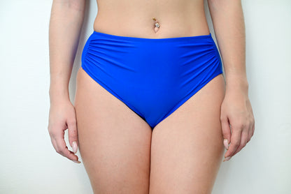 Sunlover Swimwear model wearing royal blue high-waisted swimwear on a plain background